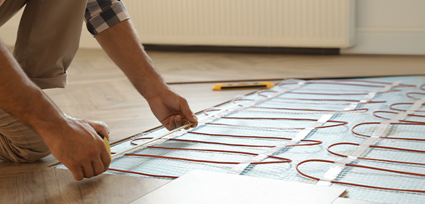 Measuring underfloor heating installation on wooden floor panels